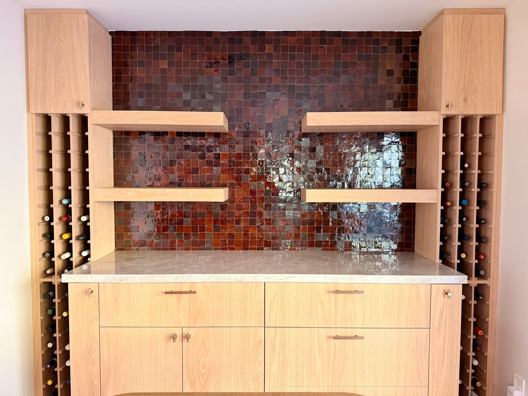 Handmade Moroccan zellige in copper and brown, set against white oak cabinetry, floating shelves and a marble counter in a Glassell Park home bar