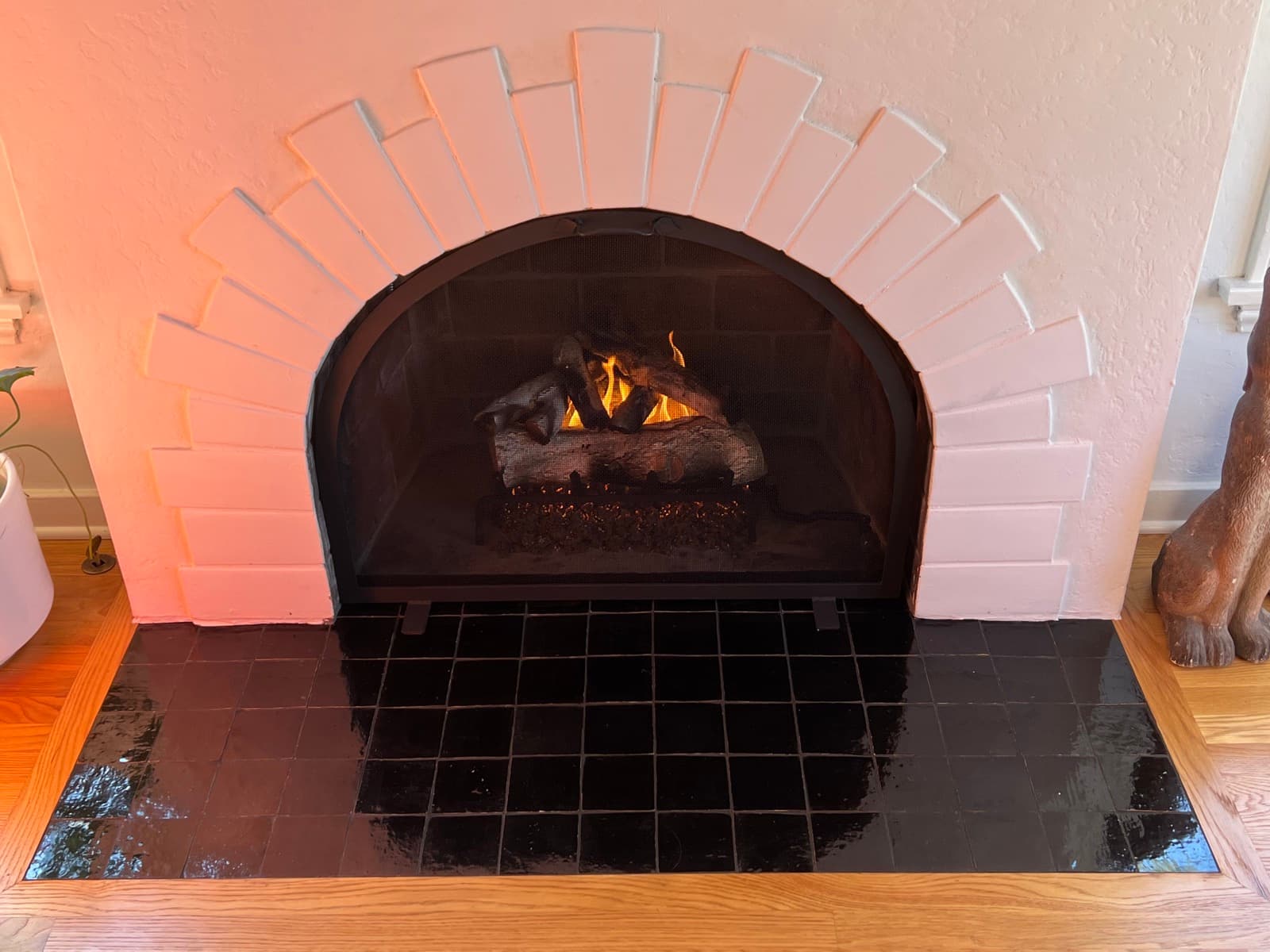 The fireplace lit, the black zellige hearth reflecting the fire.