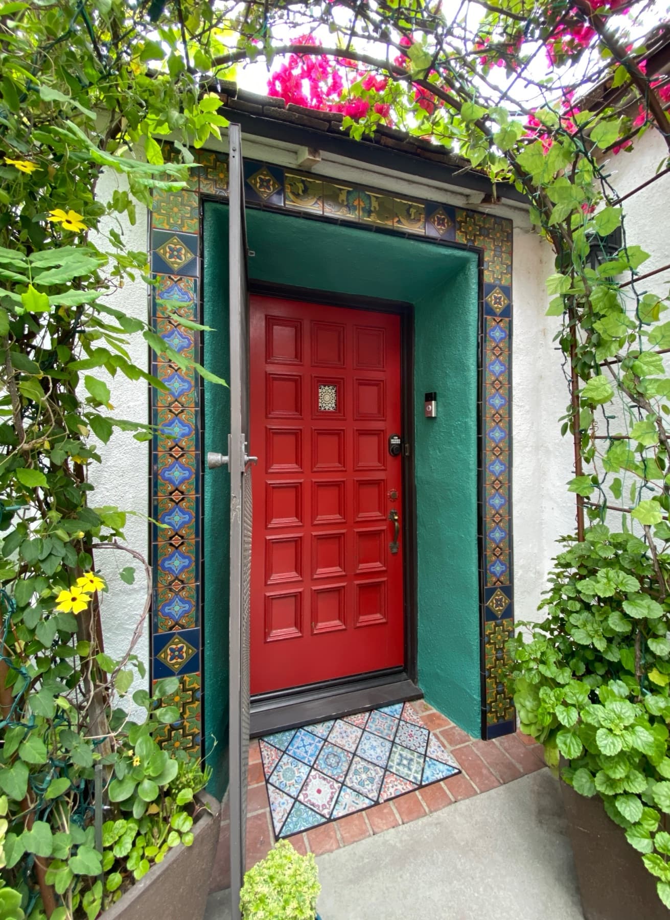 A front doorway framed in handmade Ojai Malibu tile with bougainvillea overhead, Beverly Hills