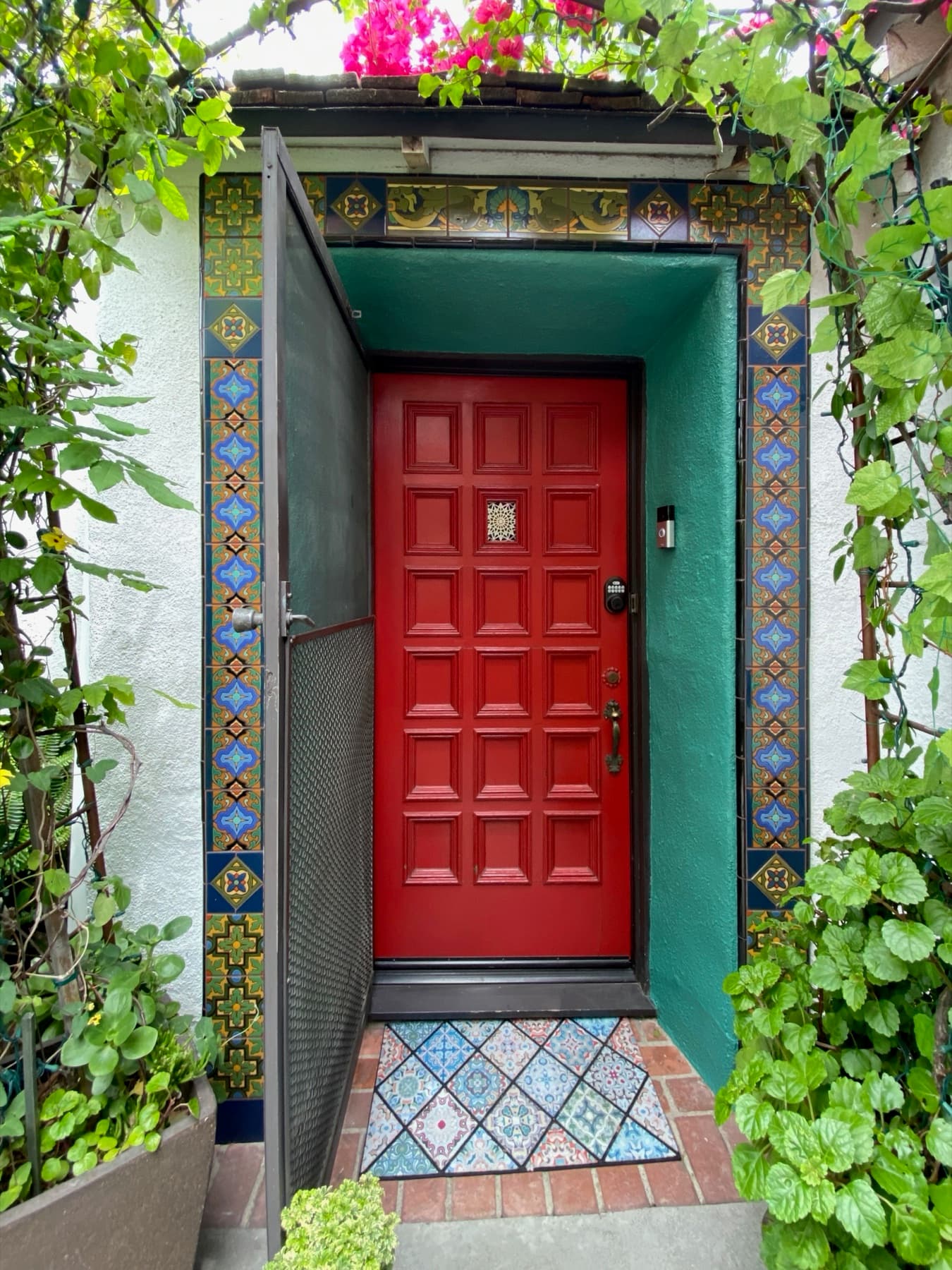 The full front doorway framed in handmade Ojai Malibu tile, bougainvillea overhead