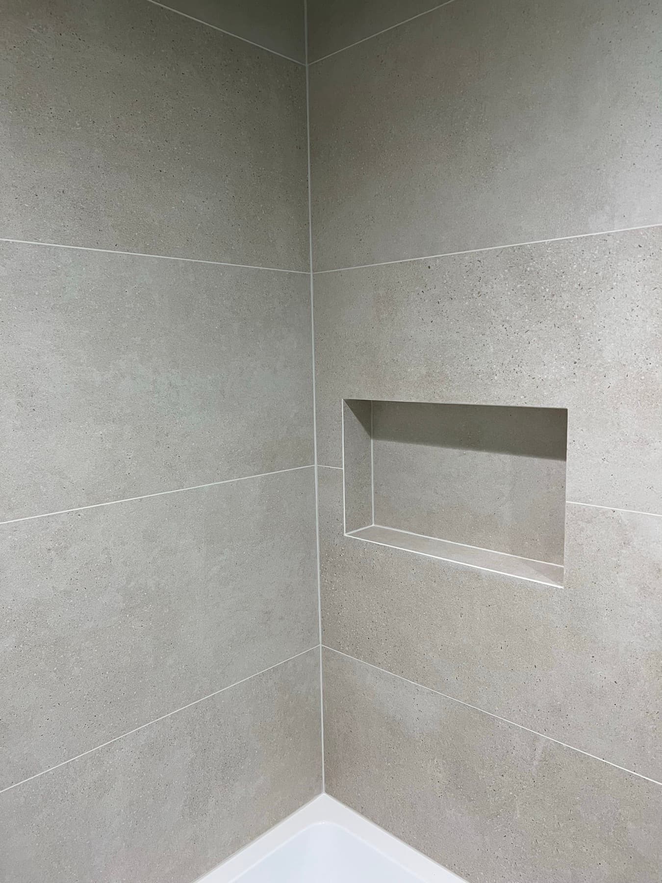 A mitered tile niche in a Lincoln Heights bathroom, every edge cut at 45 degrees with no trim